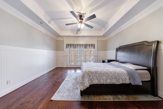 unfurnished bedroom featuring a raised ceiling, ceiling fan, dark hardwood / wood-style flooring, and crown molding