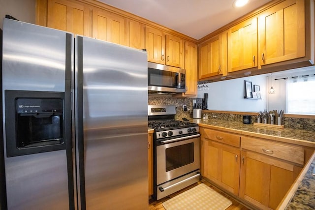 kitchen featuring backsplash, appliances with stainless steel finishes, and light hardwood / wood-style flooring