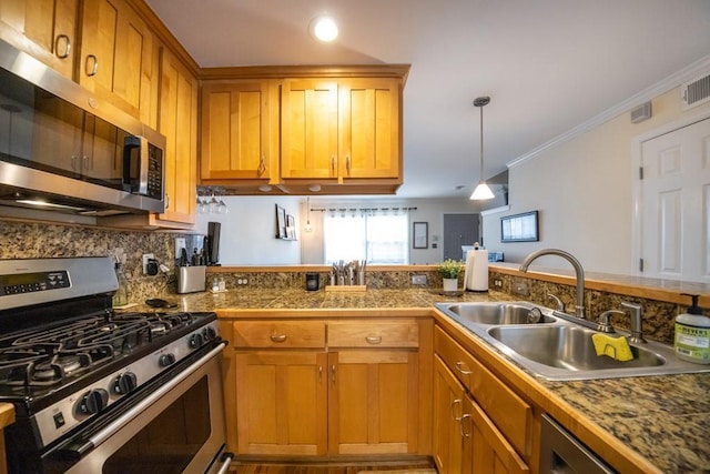 kitchen with pendant lighting, sink, ornamental molding, appliances with stainless steel finishes, and tasteful backsplash