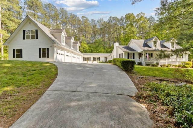 view of front facade featuring aphalt driveway, an attached garage, and a front yard