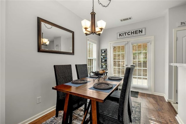 dining space with wood-type flooring and a chandelier