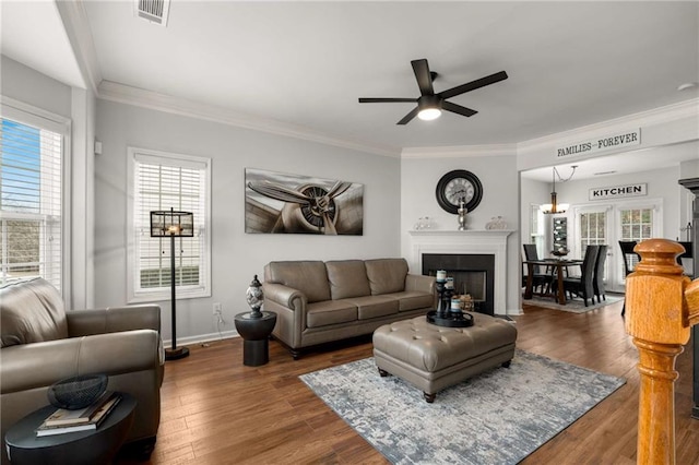 living room with dark hardwood / wood-style flooring, a wealth of natural light, and ornamental molding