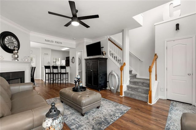 living room featuring crown molding, ceiling fan, and dark hardwood / wood-style flooring