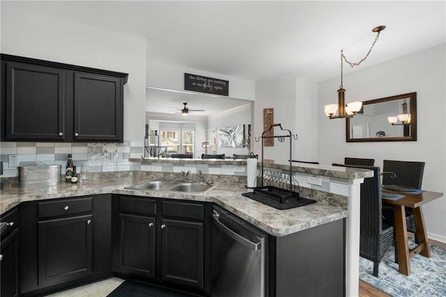 kitchen featuring sink, tasteful backsplash, light stone counters, stainless steel dishwasher, and kitchen peninsula