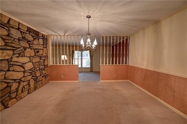 unfurnished dining area featuring a textured ceiling, a notable chandelier, carpet, and ornamental molding