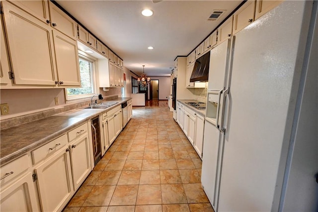 kitchen with white refrigerator with ice dispenser, pendant lighting, sink, stainless steel gas stovetop, and beverage cooler