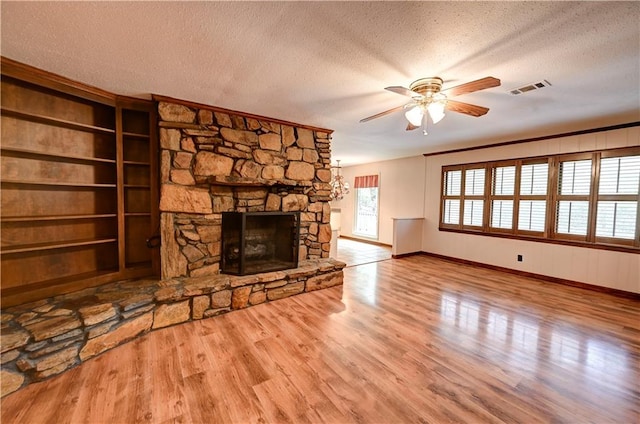 unfurnished living room with a fireplace, ceiling fan, a textured ceiling, and light hardwood / wood-style flooring