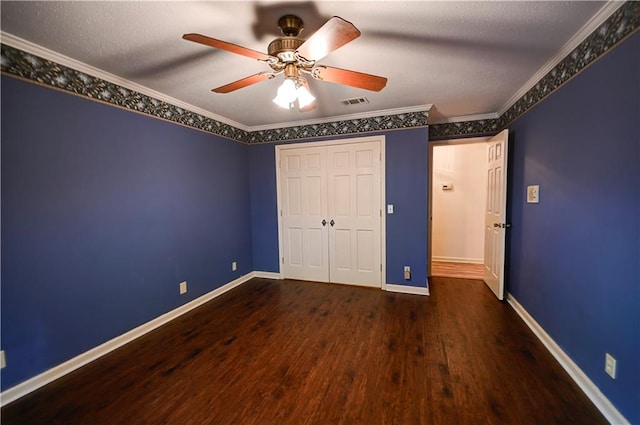 unfurnished bedroom featuring ornamental molding, ceiling fan, a textured ceiling, a closet, and dark hardwood / wood-style flooring