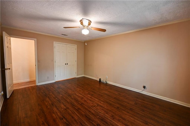 unfurnished bedroom featuring a textured ceiling, dark hardwood / wood-style flooring, ornamental molding, and ceiling fan