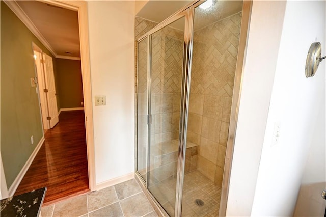 bathroom with hardwood / wood-style flooring, crown molding, and walk in shower