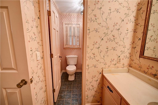 bathroom featuring toilet, vanity, and ornamental molding