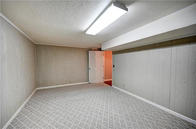 basement with wood walls, a textured ceiling, and carpet floors