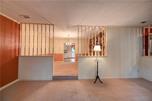 carpeted spare room featuring a notable chandelier