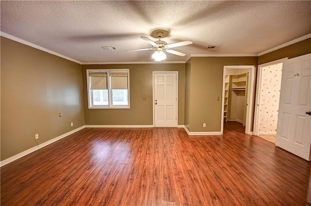 interior space featuring ceiling fan, a textured ceiling, a walk in closet, and wood-type flooring