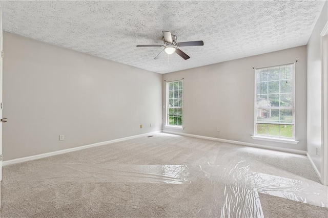 4200 Sterling Pointe Dr, Douglasville, GA 30135 - carpeted spare room featuring a ceiling fan, healthy amount of natural light, baseboards, and a textured ceiling