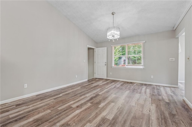 4200 Sterling Pointe Dr, Douglasville, GA 30135 - unfurnished room with a textured ceiling, wood finished floors, a chandelier, baseboards, and lofted ceiling