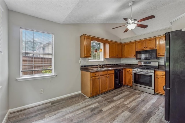 4200 Sterling Pointe Dr, Douglasville, GA 30135 - kitchen featuring black appliances, a textured ceiling, a sink, wood finished floors, and decorative backsplash
