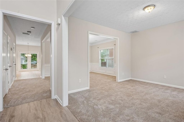 2040 Village Green Dr, Fairburn, GA 30213 - hall with plenty of natural light, carpet, a textured ceiling, wood finished floors, and french doors