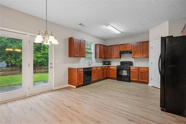 2040 Village Green Dr, Fairburn, GA 30213 - kitchen with black appliances, light wood-style floors, a chandelier, light countertops, and a textured ceiling