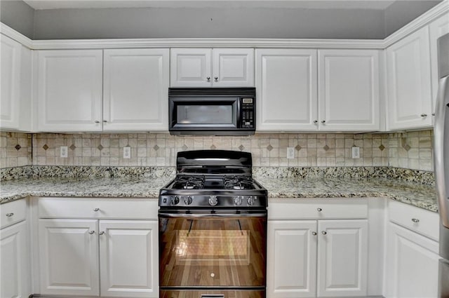kitchen featuring white cabinets, light stone counters, decorative backsplash, and black appliances