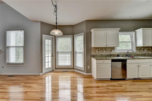 kitchen featuring white cabinets, stainless steel dishwasher, a sink, and light wood-style floors