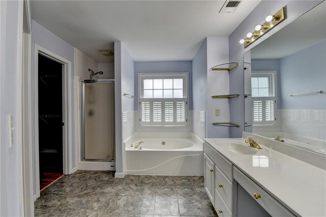 full bathroom featuring a bath, vanity, a stall shower, and visible vents