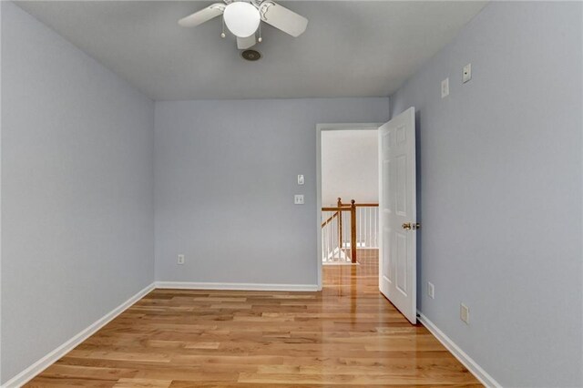 unfurnished room with light wood finished floors, baseboards, and a ceiling fan