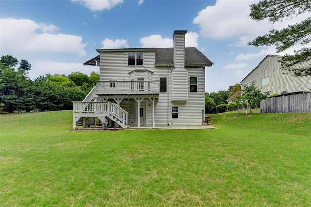 rear view of house with a lawn, a chimney, stairway, and a deck