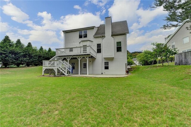 back of house with a chimney, a wooden deck, stairs, a yard, and a patio