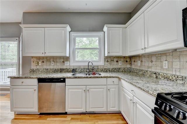 kitchen with dishwasher, white cabinets, a sink, and light wood-style flooring