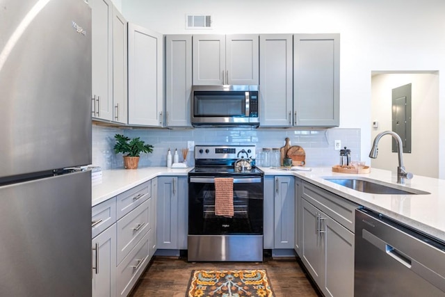 kitchen featuring dark hardwood / wood-style floors, gray cabinets, sink, and appliances with stainless steel finishes