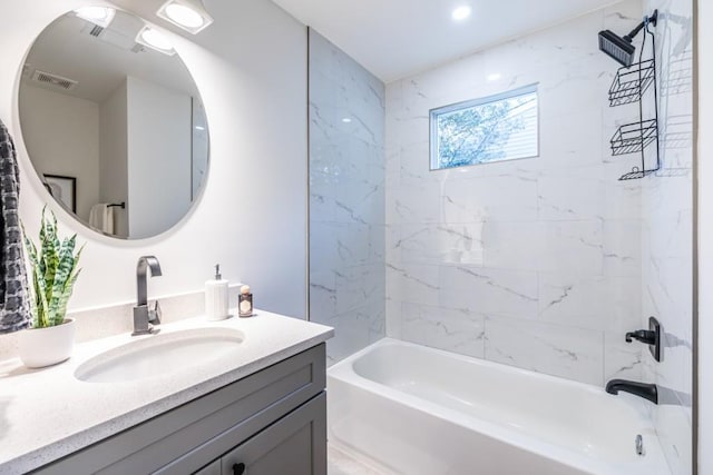 bathroom with vanity and tiled shower / bath