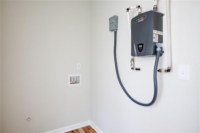 interior space with washer hookup, hardwood / wood-style floors, and tankless water heater