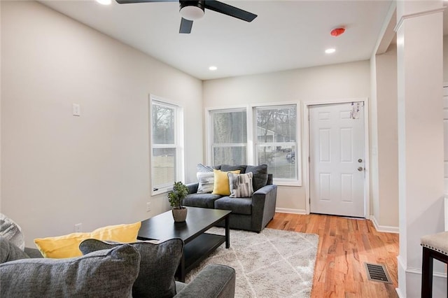 living room with ceiling fan and light hardwood / wood-style flooring