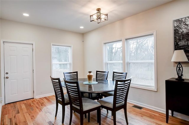 dining area with an inviting chandelier, light hardwood / wood-style flooring, and a healthy amount of sunlight