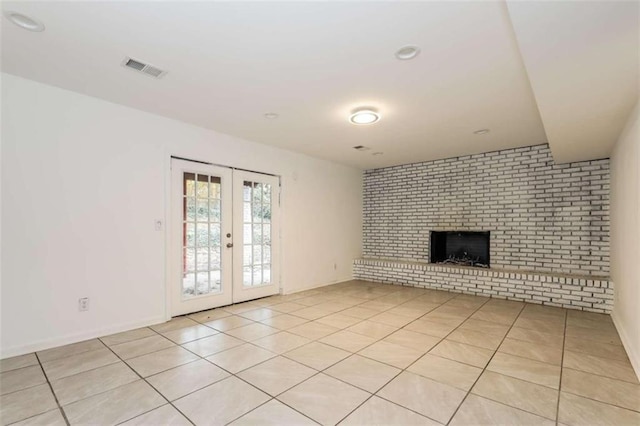 unfurnished living room with french doors, light tile patterned floors, and a fireplace