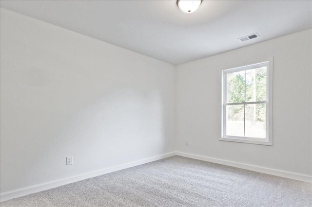 spare room with baseboards, visible vents, and carpet