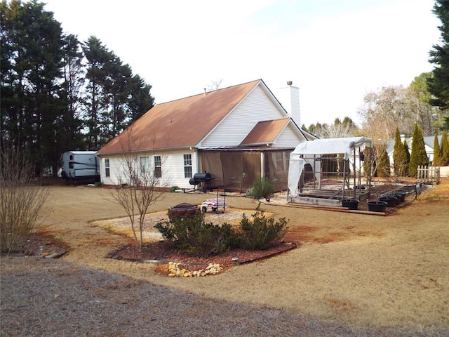 rear view of property with an outdoor fire pit