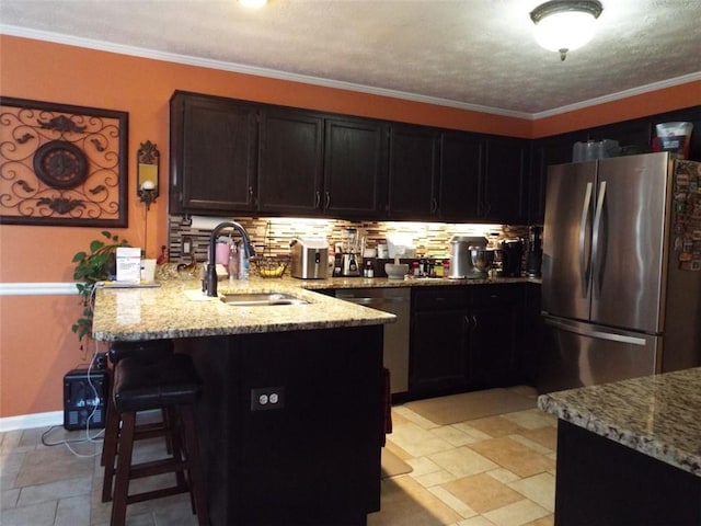 kitchen featuring ornamental molding, sink, backsplash, and stainless steel refrigerator