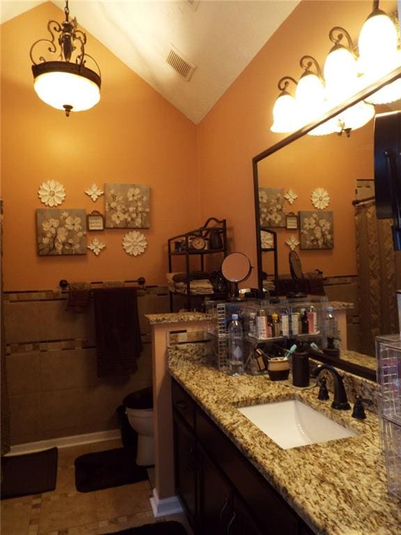 bathroom featuring vanity, vaulted ceiling, and toilet