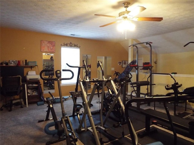 workout room with ceiling fan and a textured ceiling