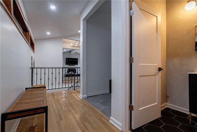 corridor with an inviting chandelier and dark wood-type flooring