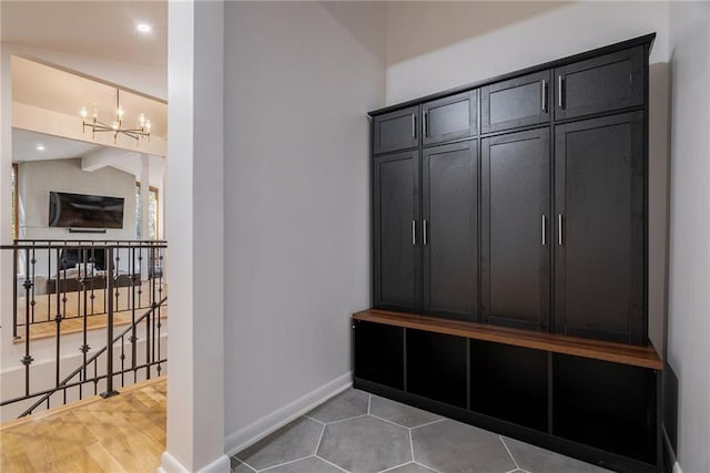 mudroom featuring hardwood / wood-style floors, vaulted ceiling, and a notable chandelier