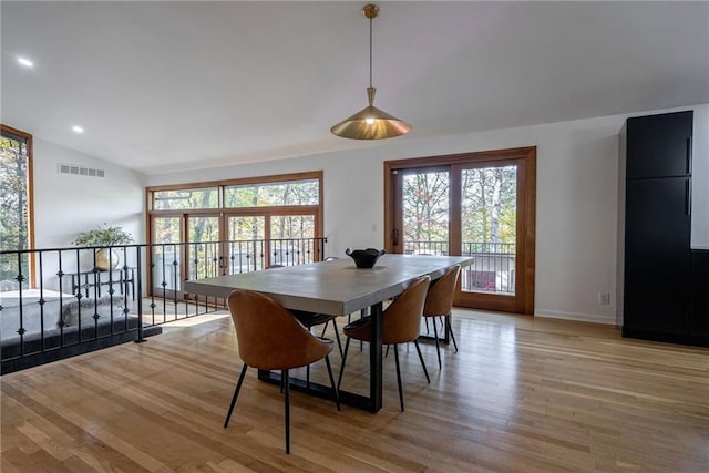 dining area with light hardwood / wood-style flooring and vaulted ceiling