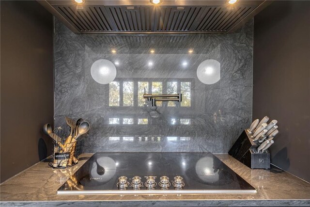 kitchen featuring wall chimney exhaust hood and black electric cooktop