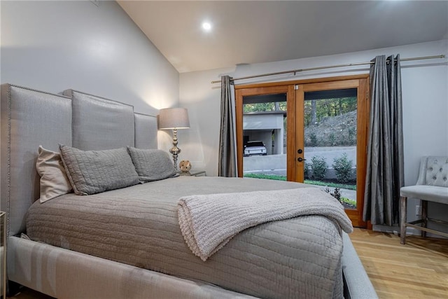 bedroom featuring light hardwood / wood-style floors, access to outside, and vaulted ceiling