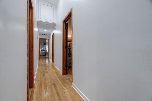 hallway with light hardwood / wood-style flooring