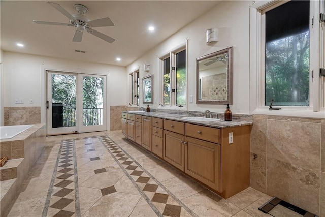 bathroom featuring vanity, ceiling fan, and tiled tub