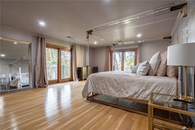 bedroom featuring multiple windows, access to exterior, and light wood-type flooring