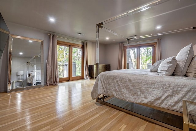 bedroom with access to outside, light hardwood / wood-style flooring, and multiple windows